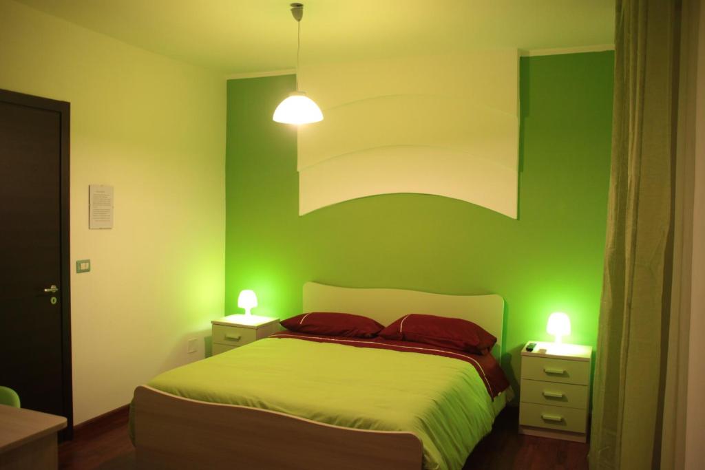 コゼンツァにあるB&B Cosenzaの緑のベッドルーム(ベッド1台、ナイトスタンド2台付)