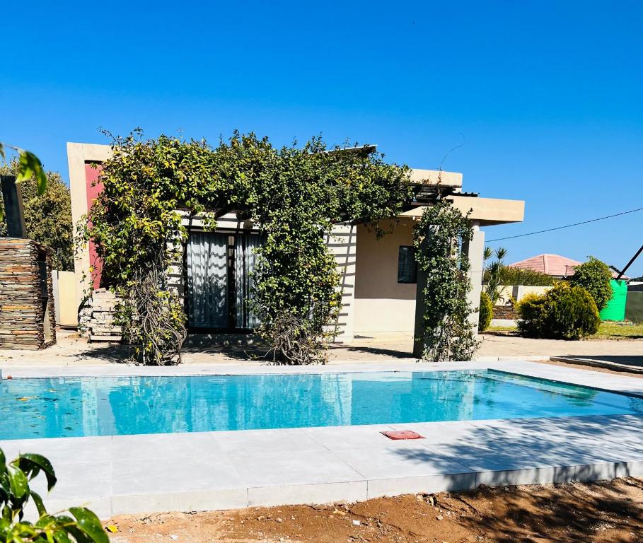 a villa with a swimming pool in front of a house at Villa 134 Modipane in Gaborone