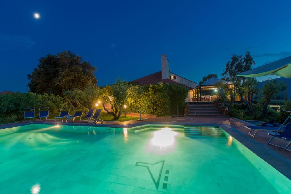 una piscina por la noche con sillas y luces en Locanda Dell'Angelo, en Ameglia