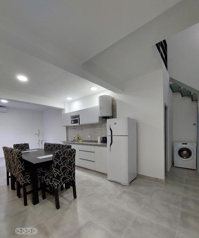 卡塔马卡DUPLEX 3的配有桌椅和冰箱的厨房