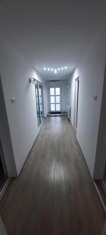 pusty pokój z białymi ścianami i drewnianą podłogą w obiekcie Anghel Florin , Rooms&Apartaments w mieście Tuzla