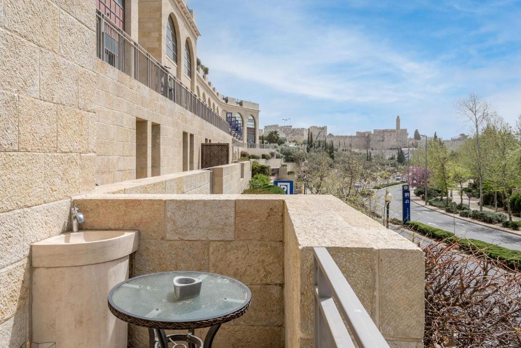 einen kleinen Tisch auf einem Steinbalkon mit einer Straße in der Unterkunft Spectacular 375 SQM at Mamilla Mall - 4 bedroom in Jerusalem