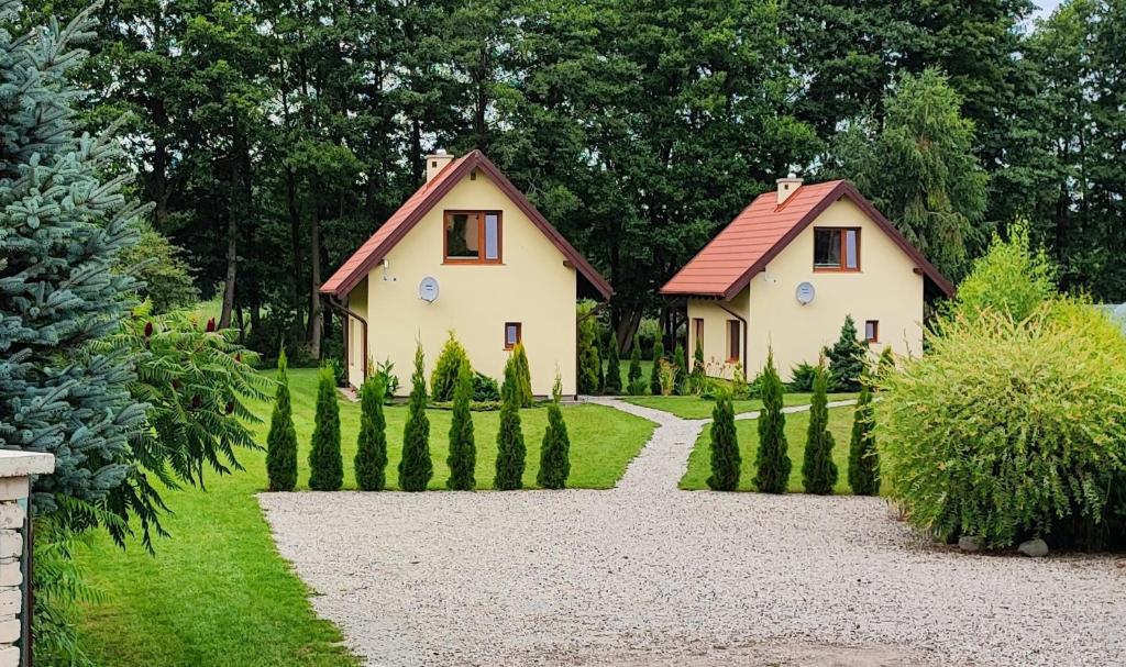 a house with a garden with a gravel driveway at Domki letniskowe Yaga in Wilkasy