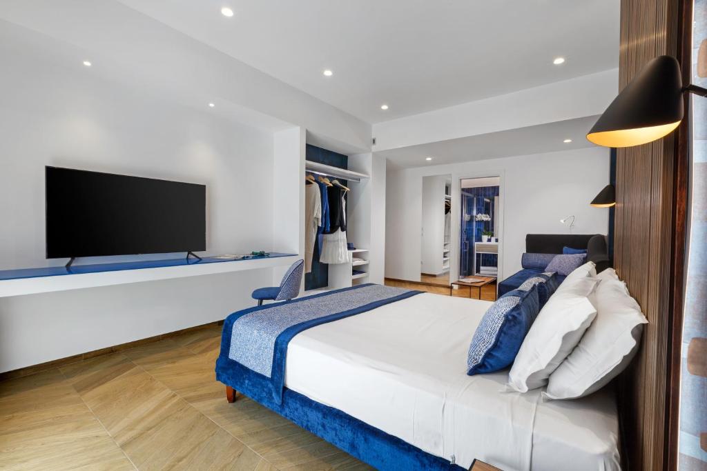Dreamers' Rooms Sorrento في سورينتو: غرفة نوم بسرير كبير وتلفزيون بشاشة مسطحة