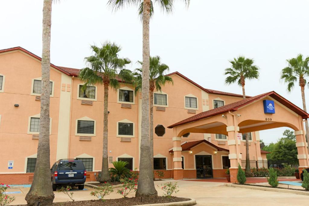 a building with palm trees in front of it at Americas Best Value Inn and Suites Houston FM 1960 in Houston