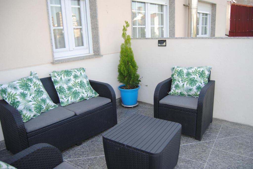2 sillas y un sofá y una mesa en el patio en Anduriña 2, en Monforte de Lemos
