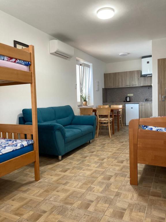 ein Wohnzimmer mit einem Sofa und einem Etagenbett in der Unterkunft Apartmány s klimatizací - Penzion U Kudláčků Pouzdřany in Pouzdřany