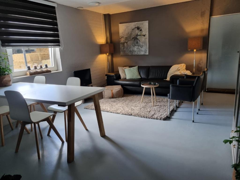 een woonkamer met een tafel en een bank bij Vakantiewoning Schouwenberg in Swalmen