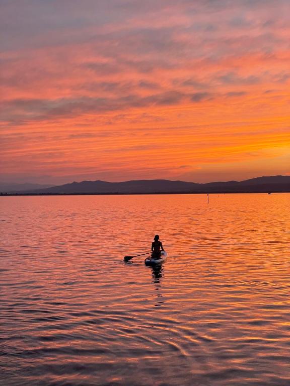 une personne dans un bateau sur un lac au coucher du soleil dans l'établissement LE SUN SET de la Coudalere, au Barcarès