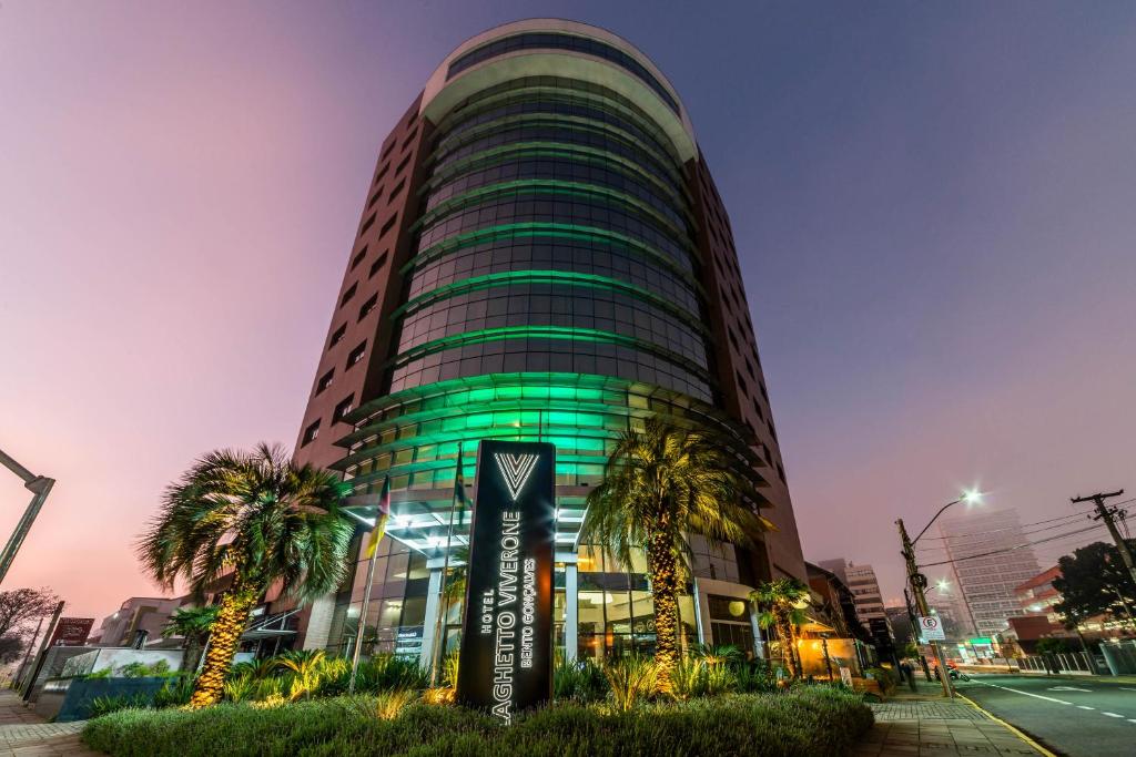 wysoki budynek z zielonymi światłami w obiekcie Hotel Laghetto Bento w mieście Bento Gonçalves