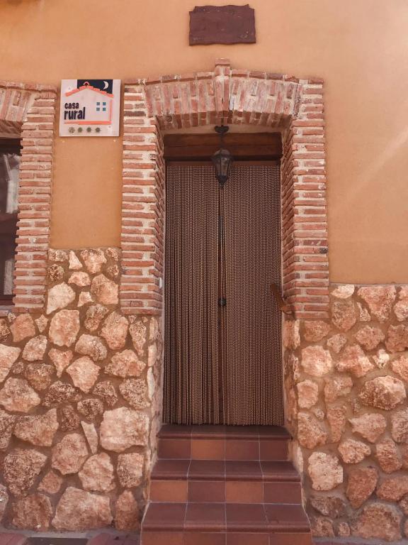 a door to a building with a stone wall at CASA RURAL LA CIJA in Maello