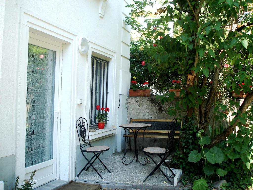 eine Terrasse mit 2 Stühlen, einem Tisch und einem Fenster in der Unterkunft Studio des Musiciens - quartier Orangerie in Straßburg