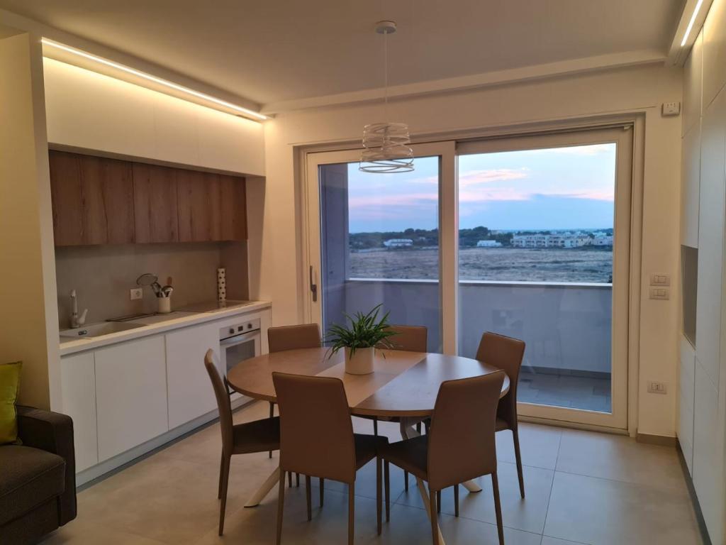 a kitchen and dining room with a table and chairs at MYHome Lecce - SalentoSouthApulia in Lecce