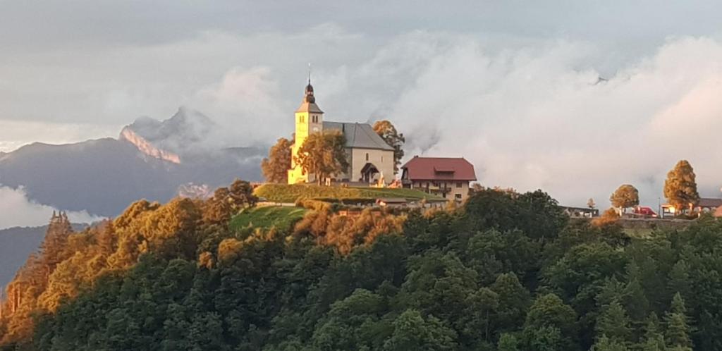 a house on a hill with a church on it at Le reposoir in Mont-Saxonnex