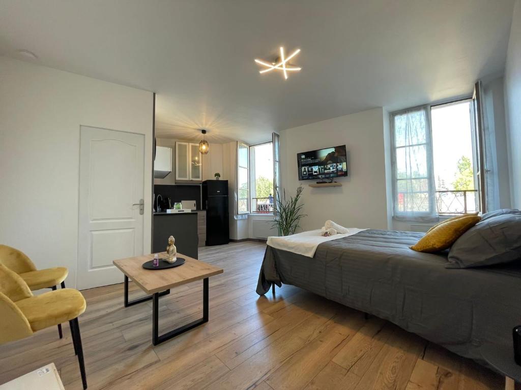 a bedroom with a bed and a table in a room at LES PIEDS DANS L’EAU - MORET CENTRE in Moret-sur-Loing