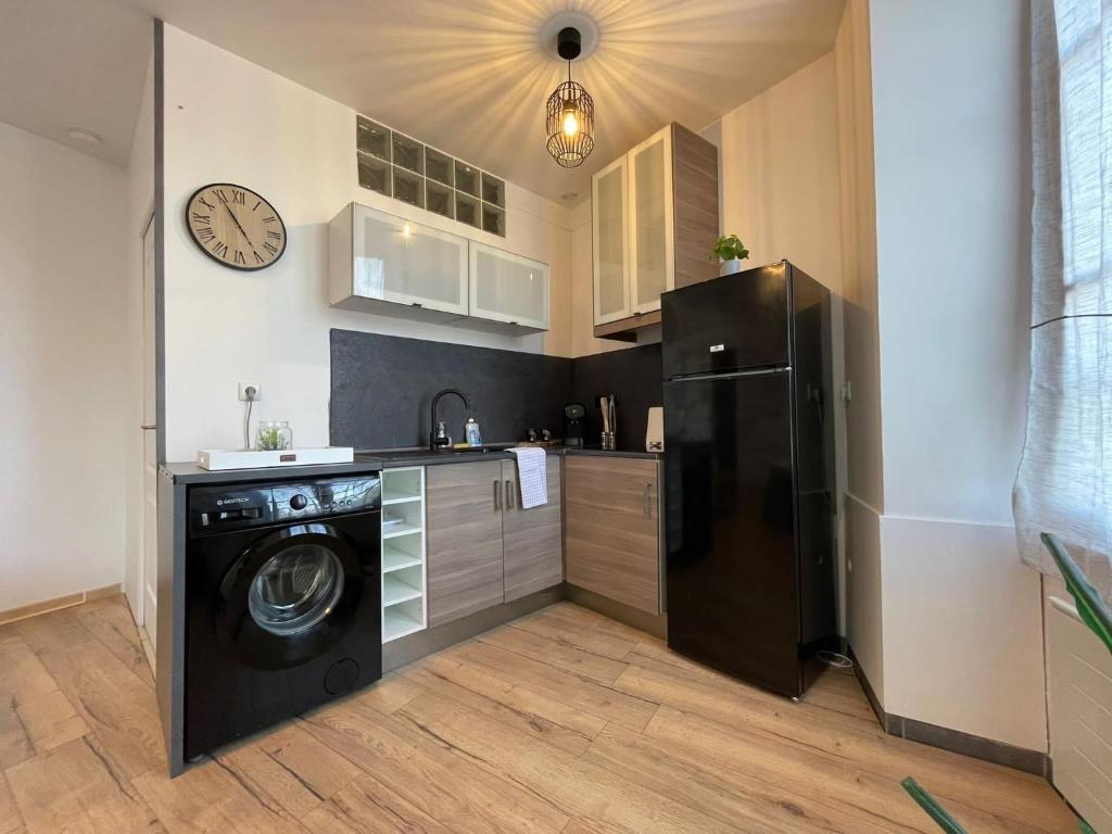 a kitchen with a black refrigerator and a dishwasher at LES PIEDS DANS L’EAU - MORET CENTRE in Moret-sur-Loing