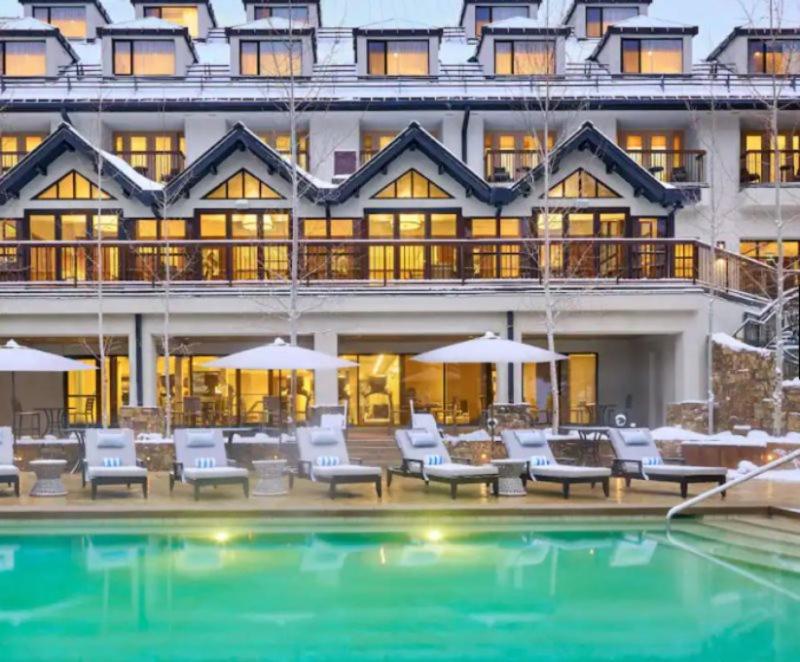 a hotel with a swimming pool in front of a building at Grand Hyatt Vail Hotel Room With King Bed in Vail