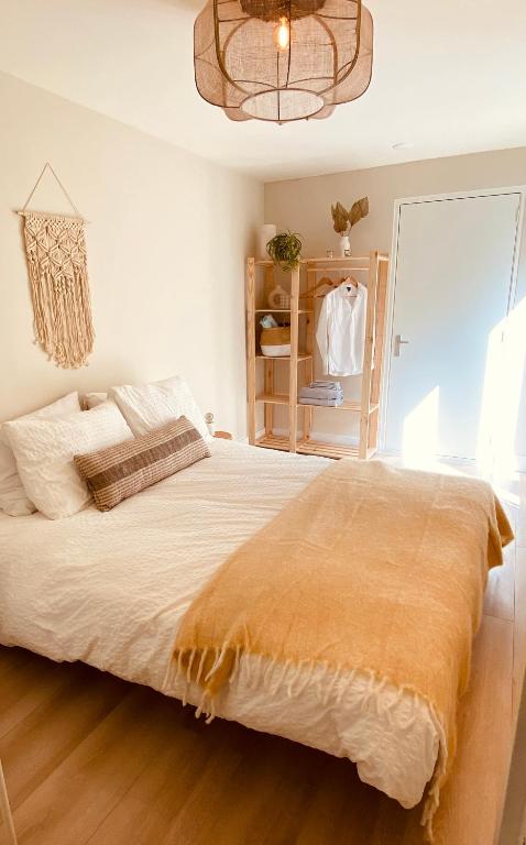 Un dormitorio con una cama grande y una lámpara de araña. en Casita aan Zee 2 slaapkamers 2 badkamers 3 min van zee, en Zandvoort