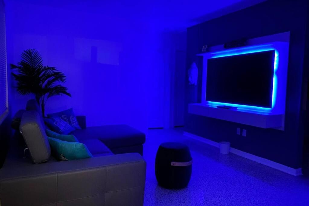 a blue room with a couch and a tv at Stayover In Miami Home 2BR - 1BTH - free parking in Miami