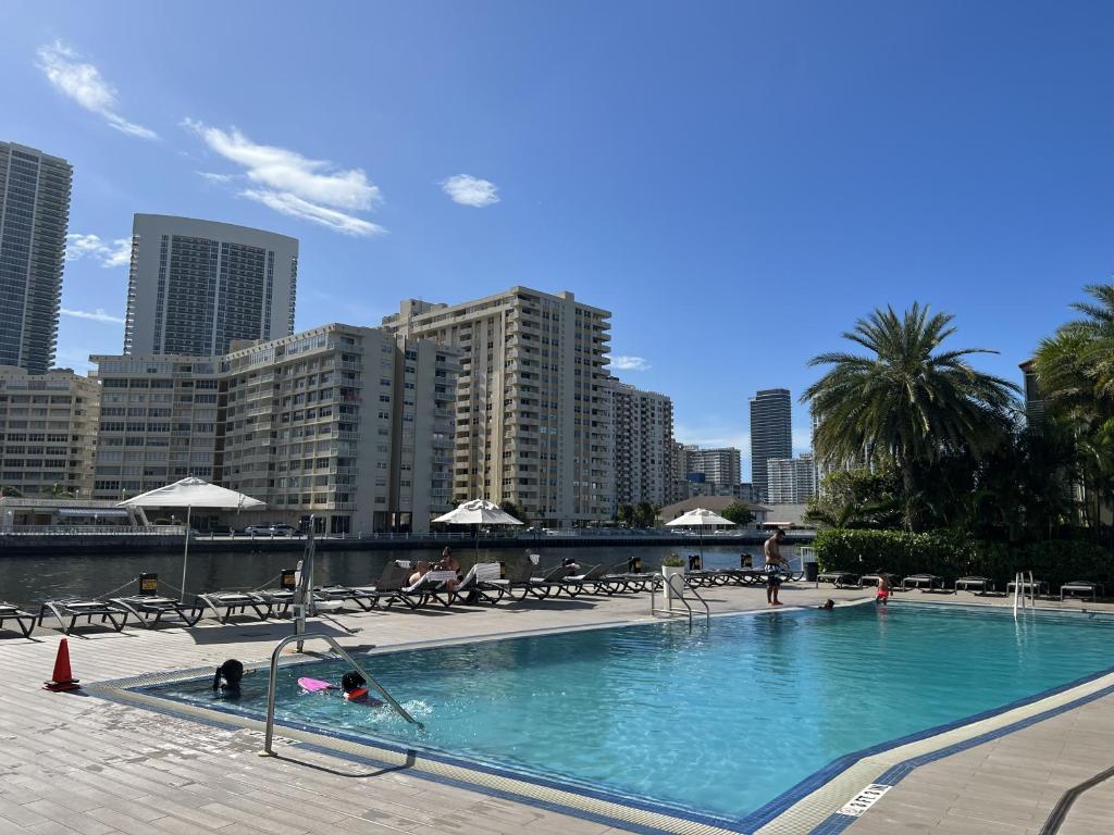 a large swimming pool in a city with buildings at 23rd floor Luxury & Spacious BeachWalk Resort Apartment with Amazing View in Hallandale Beach