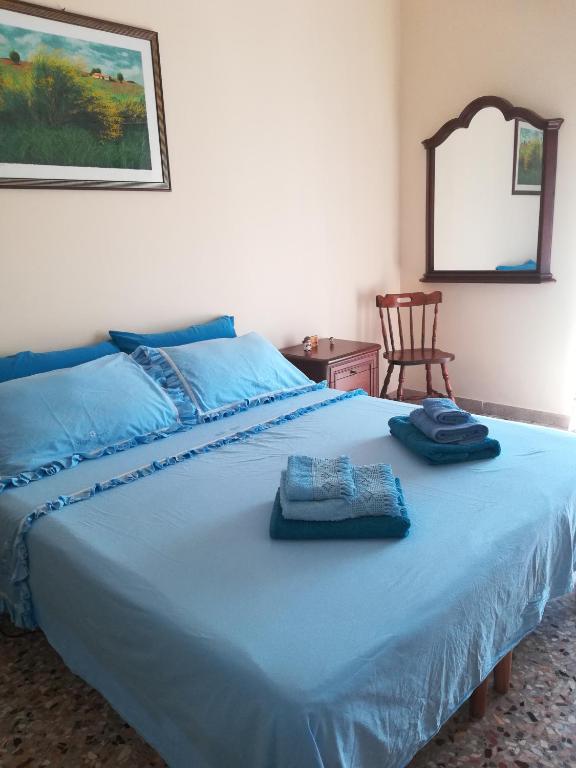 a bedroom with a blue bed with towels on it at Casa di Angela in Syracuse