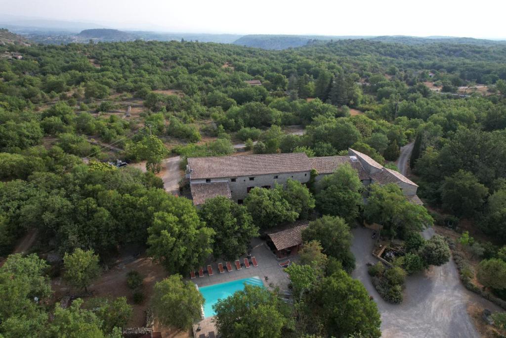 uma vista aérea de uma casa na floresta com uma piscina em Hôtel Mas de l'Espaïre em Les Vans