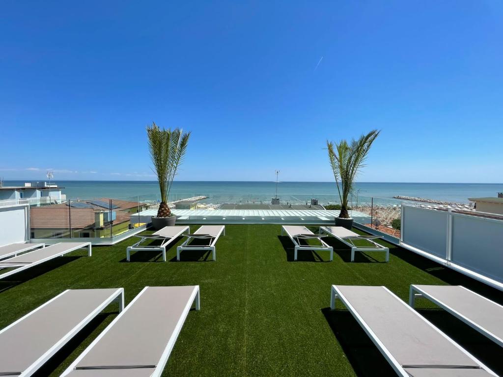 a patio with benches and the ocean in the background at MAR60 Apartments in Caorle
