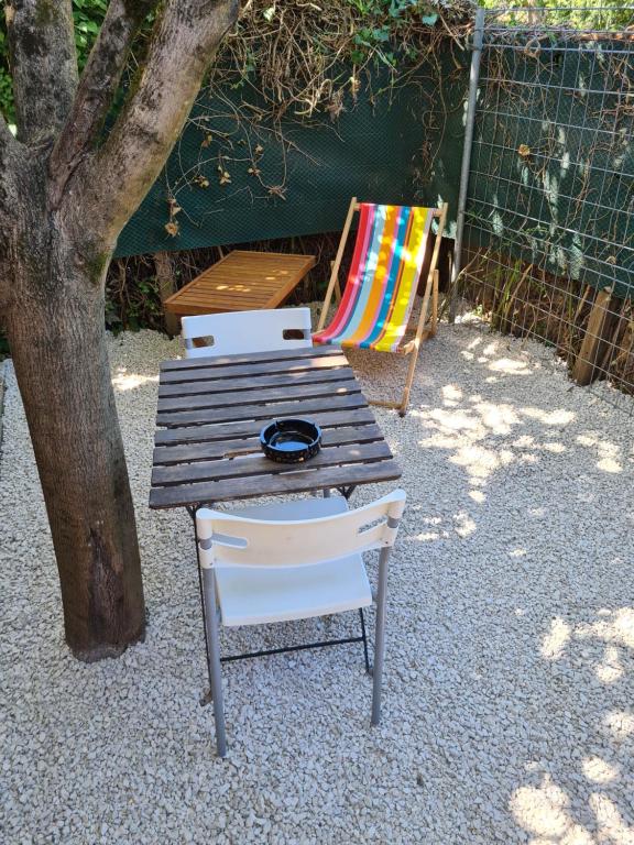 a picnic table and a chair next to a tree at Charmant logement avec parking in Orvault