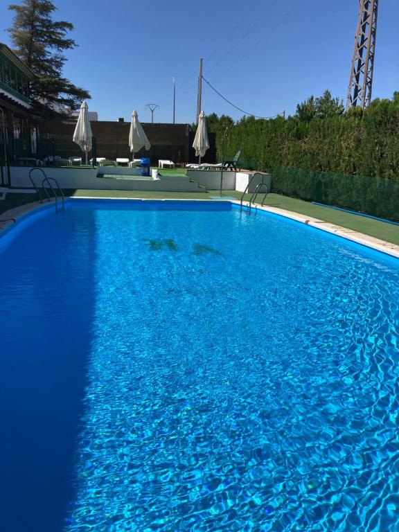 a large blue swimming pool with blue water at Hotel Almagro in Almagro