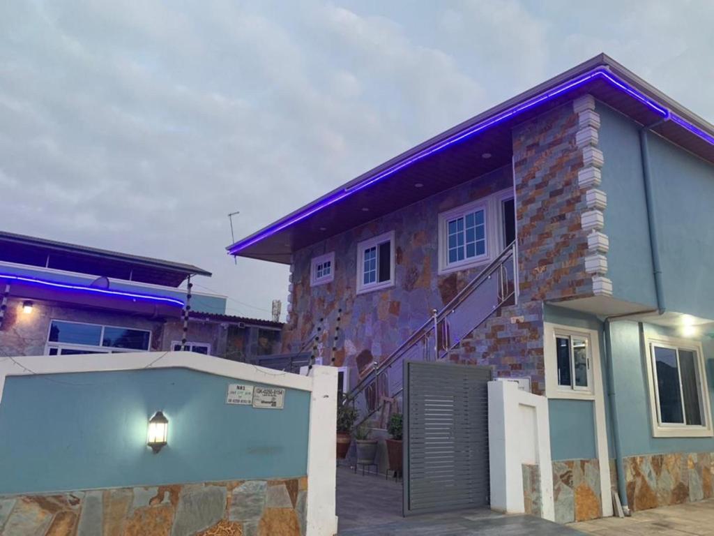ein Backsteinhaus mit einem Tor und einer Garage in der Unterkunft Lady M guest House in Tema
