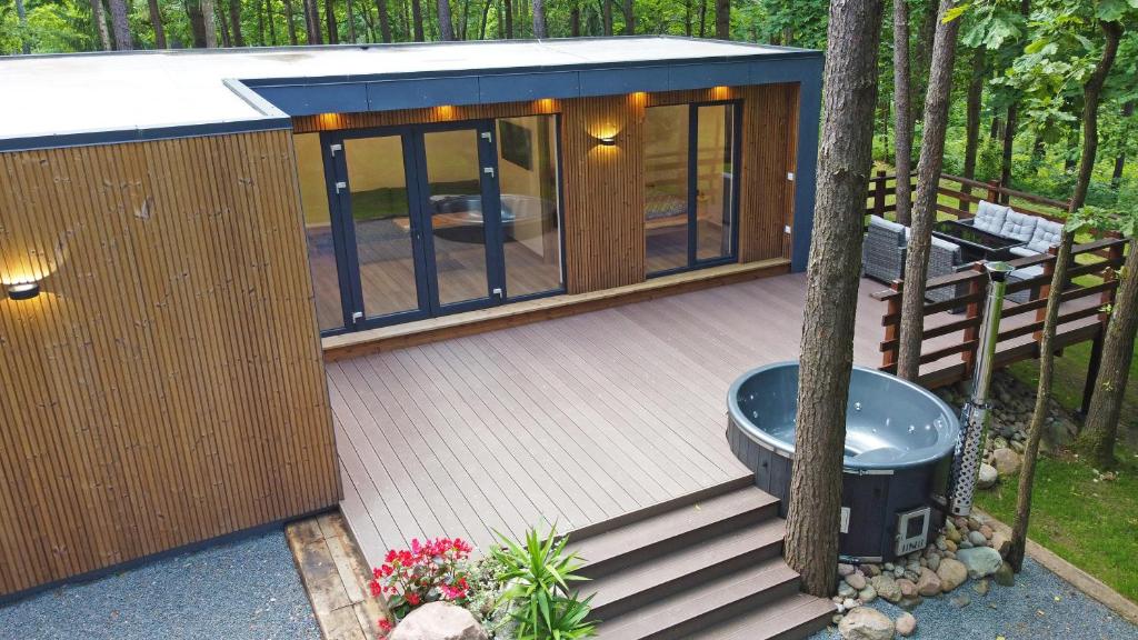 a small cabin with a deck in the woods at Forest relax 
