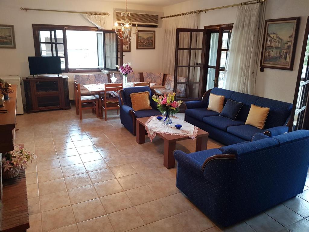 a living room with blue couches and a table at Rustic by the Sea in Flogita