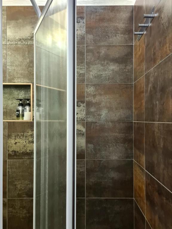 prysznic ze szklanymi drzwiami w łazience w obiekcie Serendipity Apartments - Montenapoleone w Mediolanie