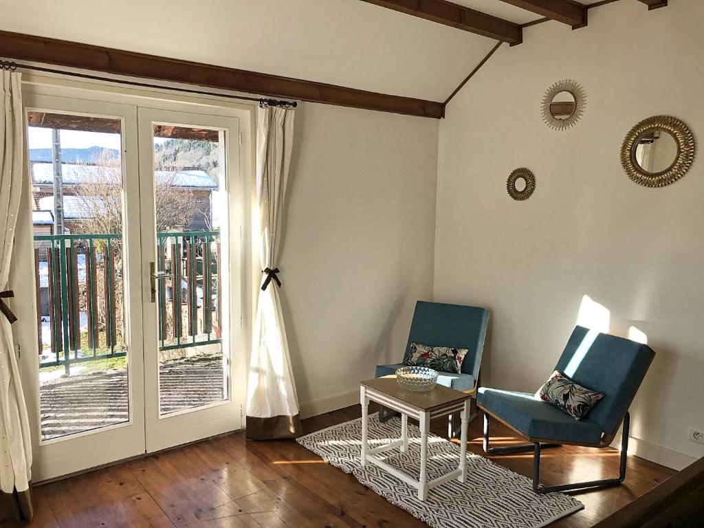 2 Stühle und ein Tisch in einem Zimmer mit Fenster in der Unterkunft Relais des Combettes in Sutrieu