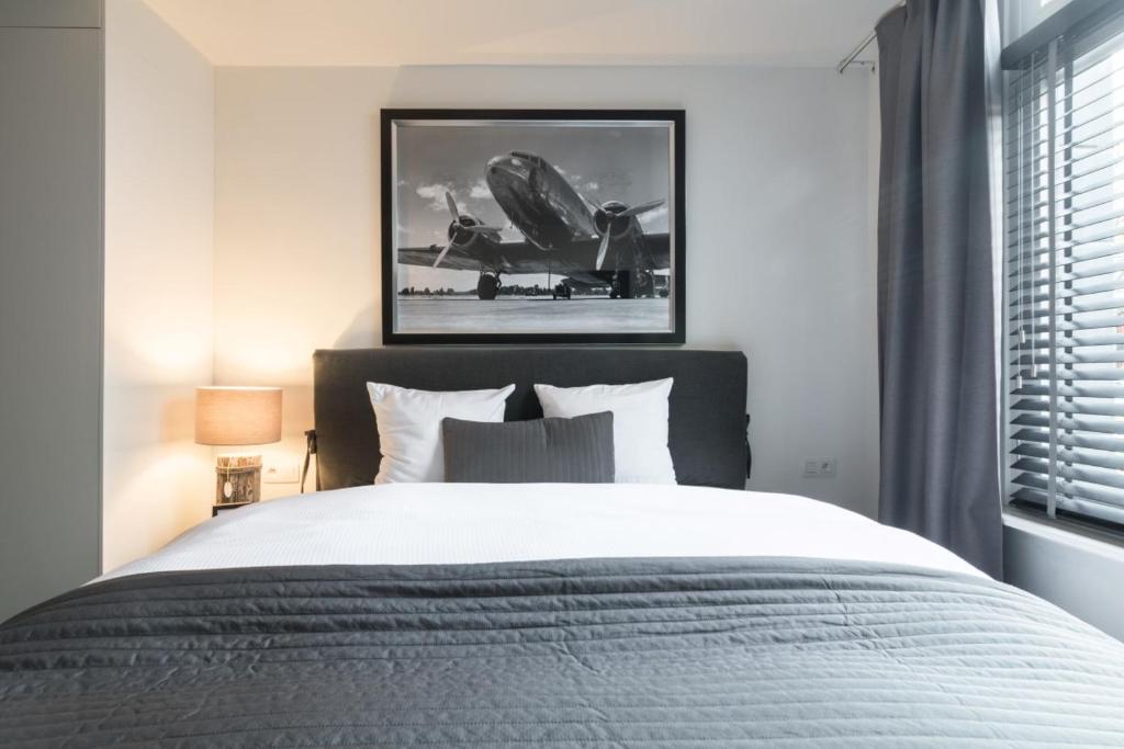 een slaapkamer met een groot bed en een foto aan de muur bij Turnhout City Hotel in Turnhout