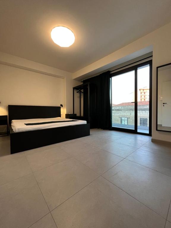 - une chambre avec un lit et une grande fenêtre dans l'établissement The Loft, à Milazzo