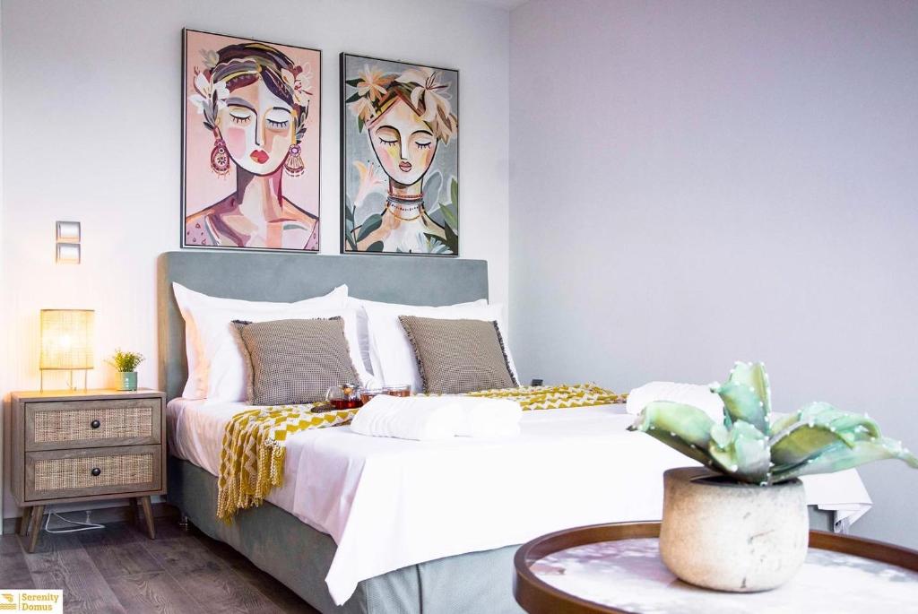a bedroom with a bed with two paintings on the wall at Serenity Domus in Lefkimmi