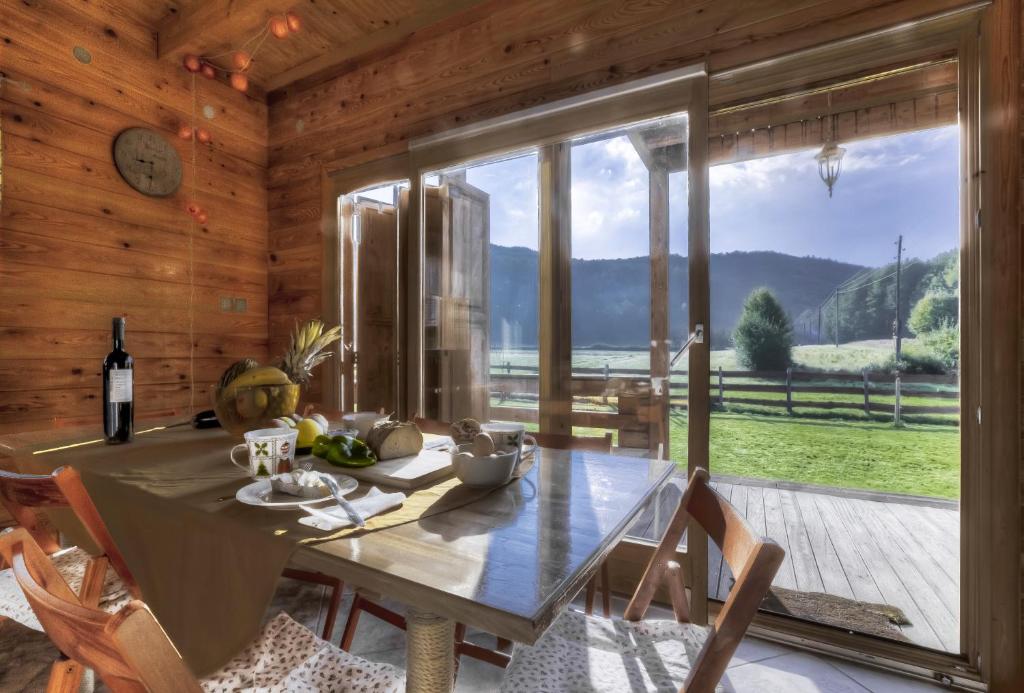 a dining room with a table and a large window at Chalet Sanjam Liku in Bužim