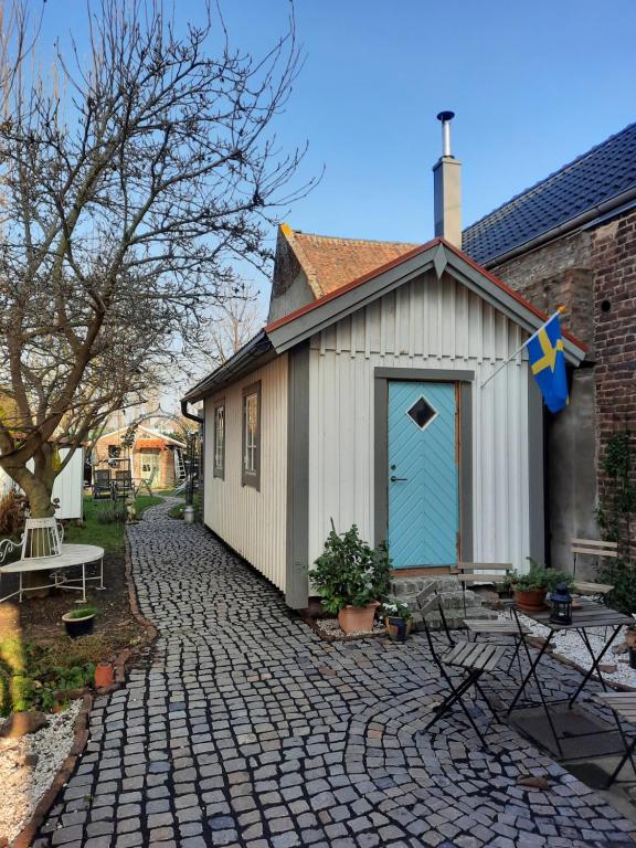 a small shed with a blue door on a brick driveway at Schwedenliebe in Frechen