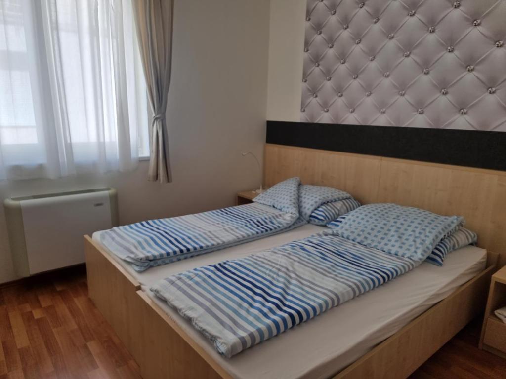 a bedroom with a large bed with a padded headboard at Panorama View Apartment in Hajdúszoboszló