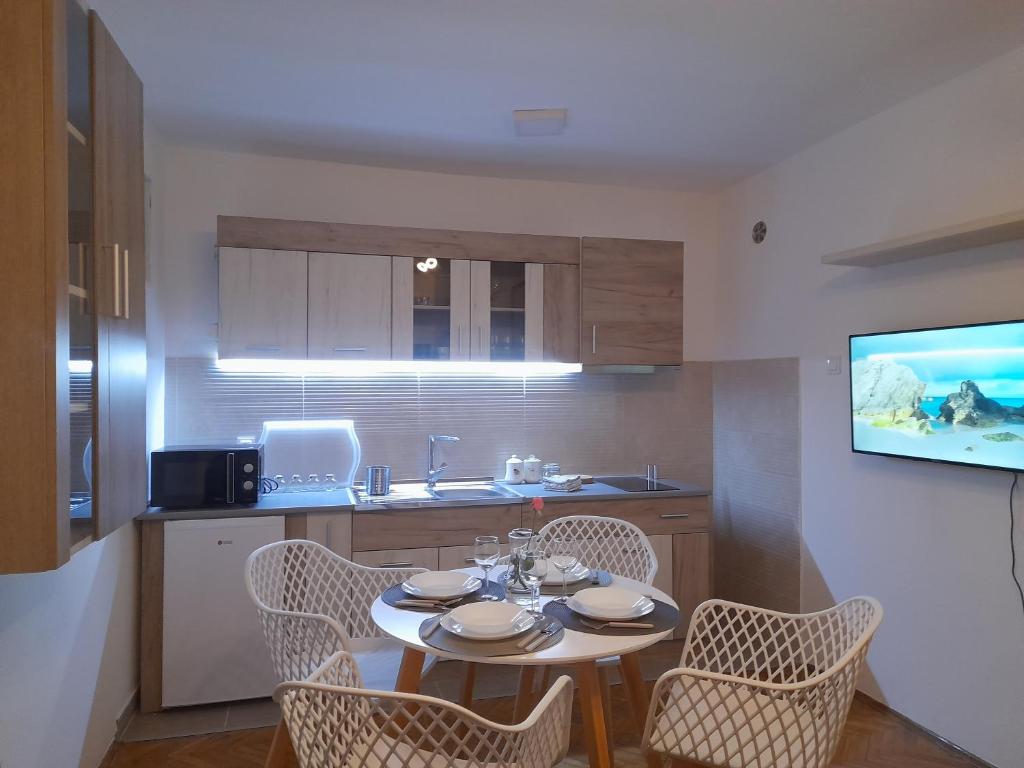 a kitchen with a table with chairs and a tv at Apartman Stevan in Pirot