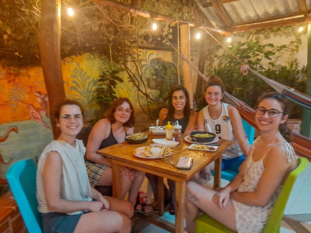 un gruppo di ragazze sedute intorno a un tavolo di Hostal Baruch a Buritaca