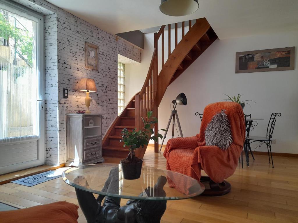 - un salon avec une table en verre et un escalier dans l'établissement Maison de village avec cour intérieure et terrasse, à Septfonds