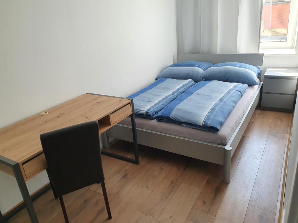 a bed with blue pillows and a table in a room at Apartment RITHEL in Vienna