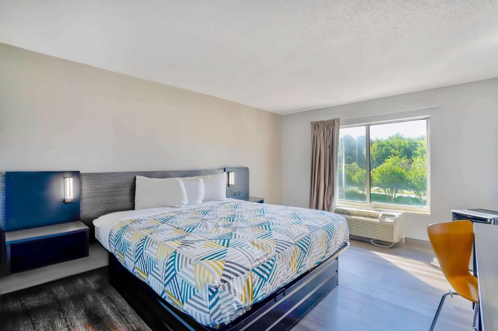 a hotel room with a bed and a window at Motel 6 Virginia Beach in Virginia Beach