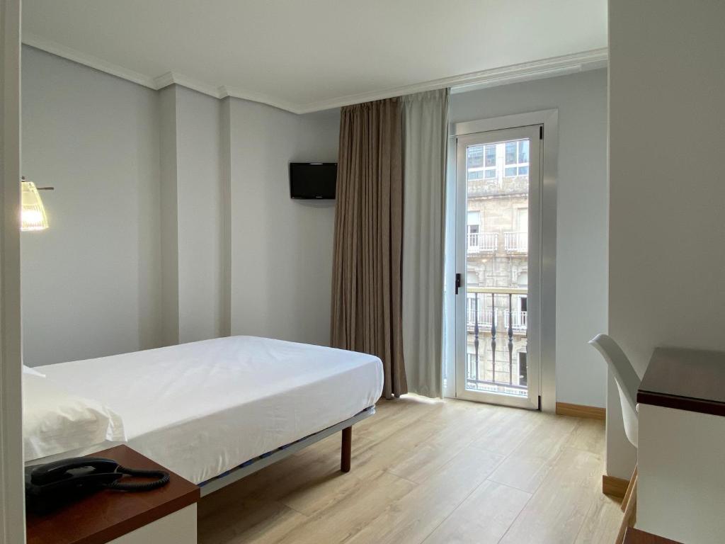 a hotel room with a bed and a window at Hotel Arsus in Vigo