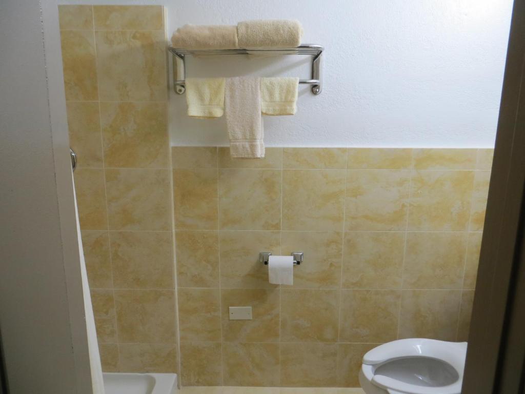 a small bathroom with a toilet and towels at Budget Inn Lake Wales in Lake Wales