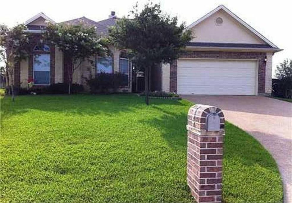 a house with a brick mailbox in front of a yard at Century Tree Lodge - Family & Football Friendly in College Station