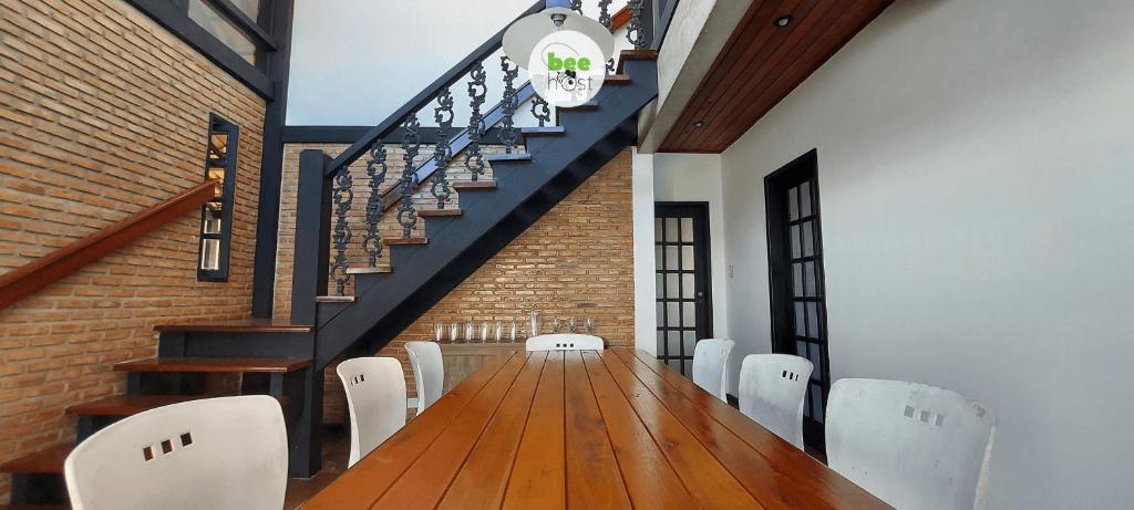 a dining room with a wooden table and white chairs at COSTE0101 - Casa com piscina em Stella Maris in Salvador