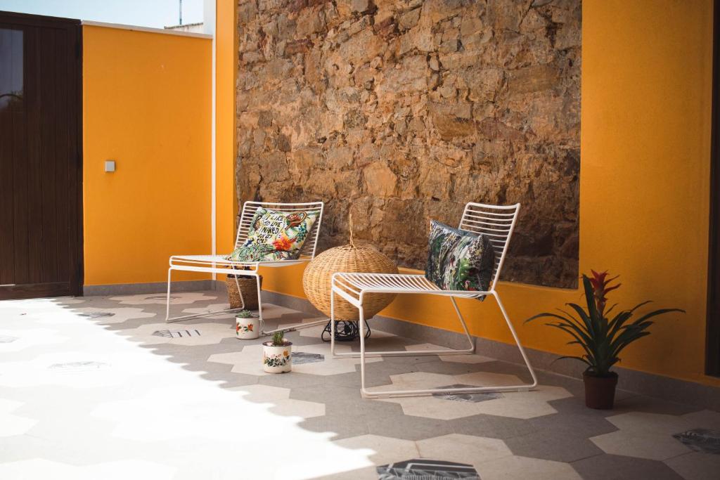 two chairs sitting next to a stone wall at Laurus - Charming House in Raposeira